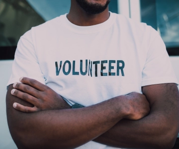 Man with shirt that has Volunteer written across it.