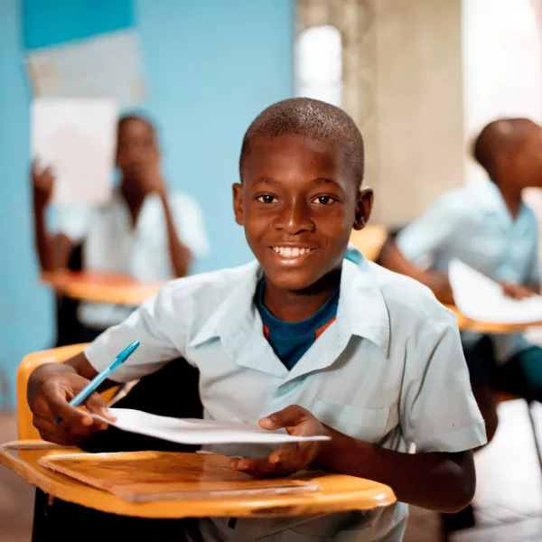 Child Sitting at Desk in Classroom